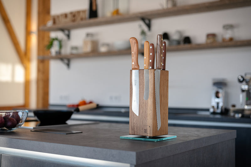 Nussbaum Messerblock auf einer Kücheninsel der mit mehreren Messern bestückt ist.